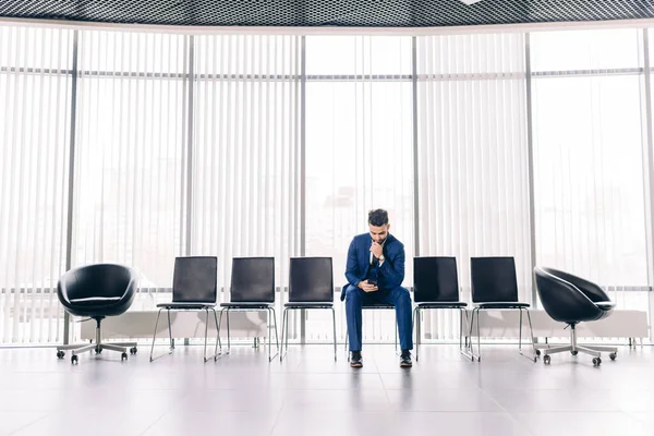 lonely handsome man fashion suit sitting with smartphone