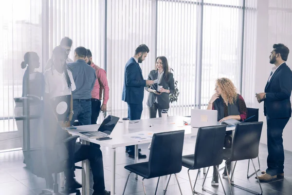 Diverse lächelnde Geschäftsleute unterhalten sich bei Treffen im Stehen. — Stockfoto