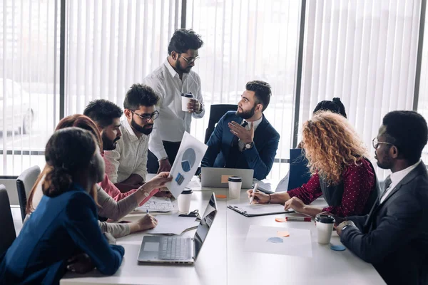 Handsome Chief Executive im Gespräch mit indischen männlichen Assistenten während eines Treffens — Stockfoto