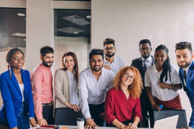 Genç ve başarılı melez iş adamları kameraya bakıyor.
