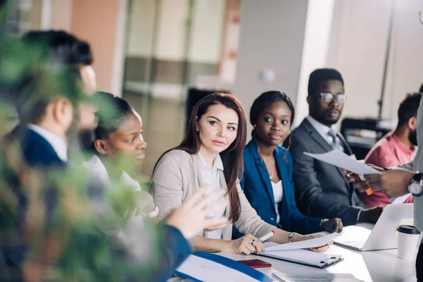 Gemischte Rassen lauschen Präsentation in Reihe am Vorstandstisch — Stockfoto