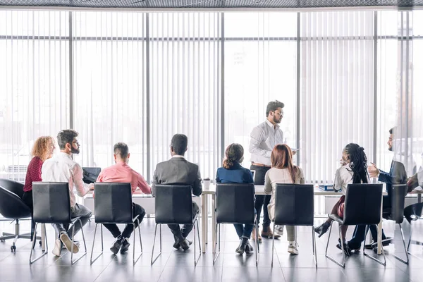 Rad av oigenkännliga affärsmän sitter i konferenslokal på business event. — Stockfoto