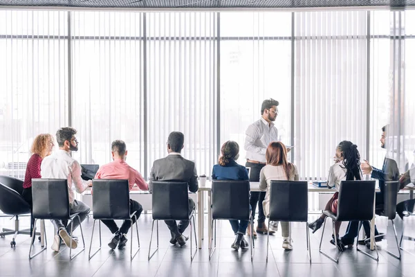 Fila de empresarios irreconocibles se sientan en la sala de conferencias en el evento de negocios. — Foto de Stock