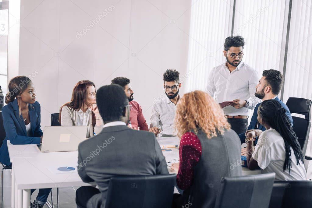 Multiracial business coworkers talking, interacting on workplaces