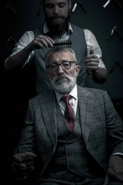 理容室の椅子に座ってヘアカットのデザインを選ぶひげそりの古いビジネスマン — ストック写真