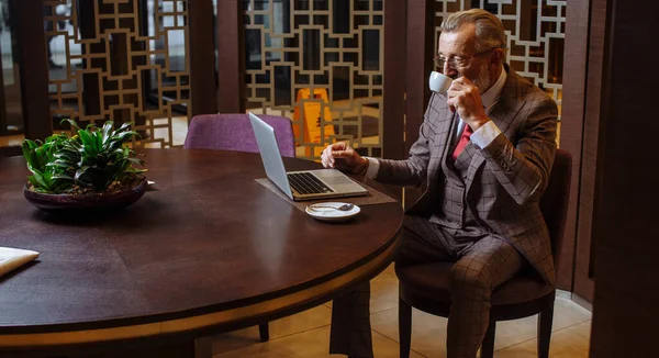 Viejo Empresario con portátil en la pausa de café en su concepto de oficina —  Fotos de Stock