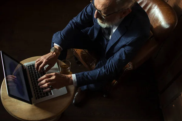 Dramaturgo senior mirando el portátil, creando novela mientras está sentado en el pub. — Foto de Stock