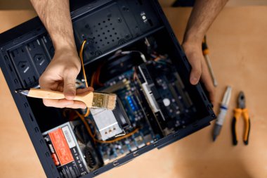 Adam toprağı ve tozu temizliyor.