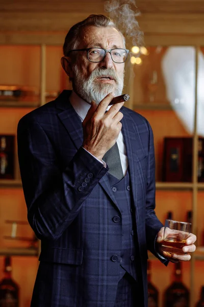 Anciano hombre de negocios en traje formal con whisky y cigarro en lux — Foto de Stock