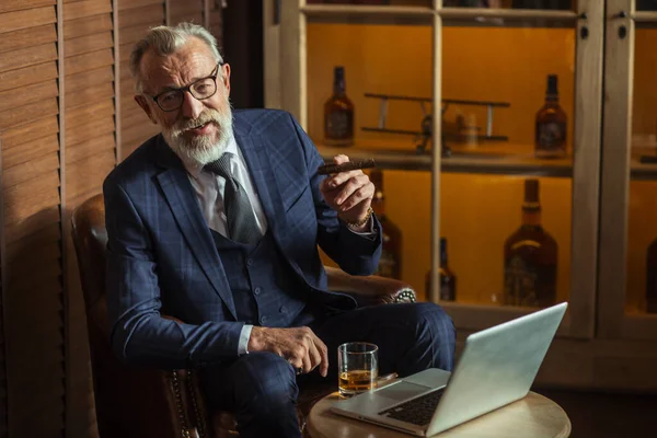 Senior dramaticus op zoek naar laptop, het creëren van nieuwe terwijl zitten in de pub. — Stockfoto