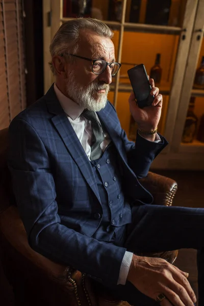 Antiguo médico privado con experiencia hablando en teléfono inteligente con el paciente en el interior. — Foto de Stock