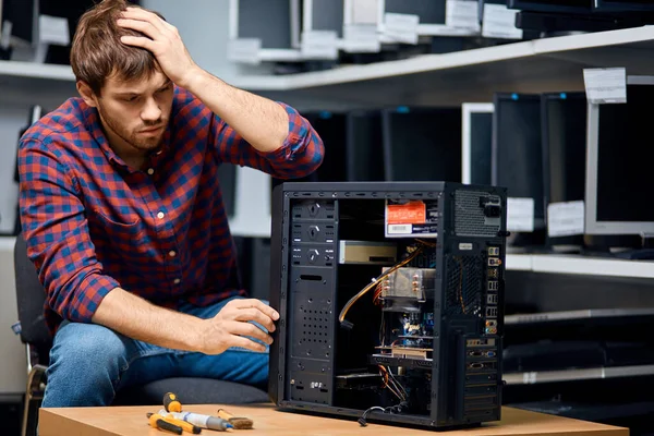 Hombre pensativo infeliz buscando hardware de reparación confuso —  Fotos de Stock