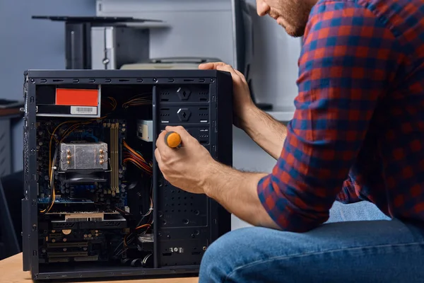 Man met schroevendraaier die een systeem demonteert — Stockfoto