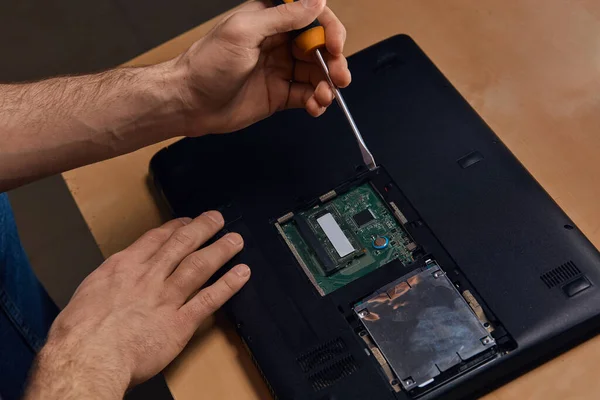 Man met schroevendraaier en reparatie van een kapotte laptop voor klanten — Stockfoto