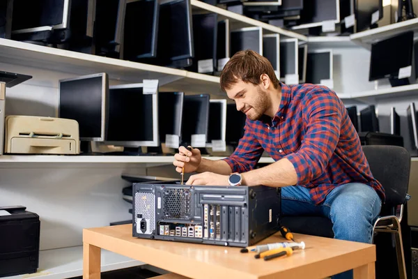 Onderhoud van de systeemeenheid. knappe vrolijke man leren om computer te repareren — Stockfoto