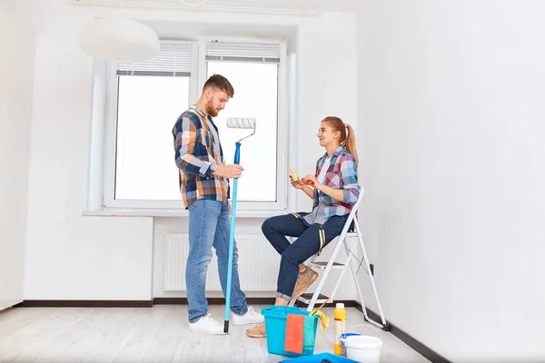 People, renovation concept - Young woman and man discussing new apartment — Stock Photo, Image