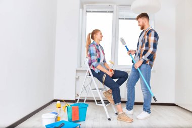 İnsanlar, yenileme konsepti - genç kadın ve erkek yeni daireyi tartışıyor