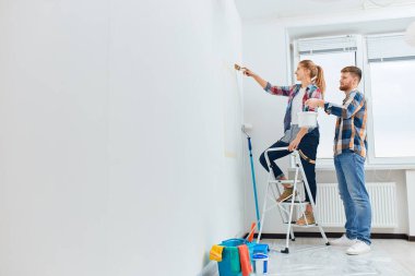 Mutlu çift yeni evlerini yenilemek için bir silindir kullanıyor.