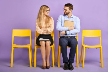 gülümseyen genç erkek kağıtları tutuyor ve bayan iş arkadaşı