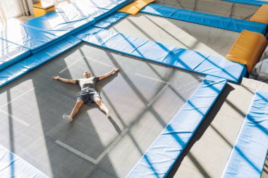 Trambolinde gevşeyen, gözleri kapalı genç sporcu.