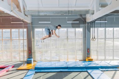 Genç hırslı sporcu spor salonunda dublörlük yapacak.