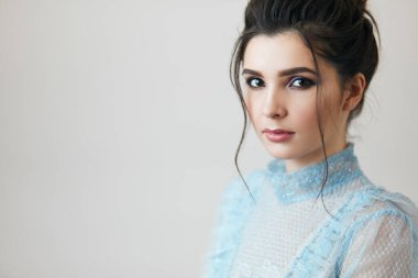 Güzel saç stili ve elbisesi olan büyüleyici bir kız.