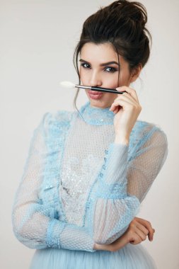 Komik kız bıyık gibi fırça kullanıyor.