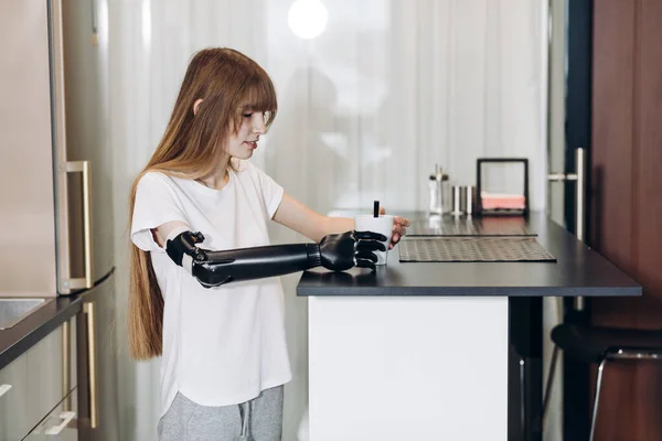 Adaaptatie, jong meisje leren om een kopje thee vast te houden — Stockfoto