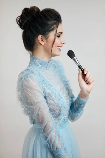 Sorrindo menina chique se divertindo com um pincel — Fotografia de Stock