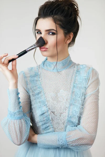 Güzel bayan burnunu pudralıyor.