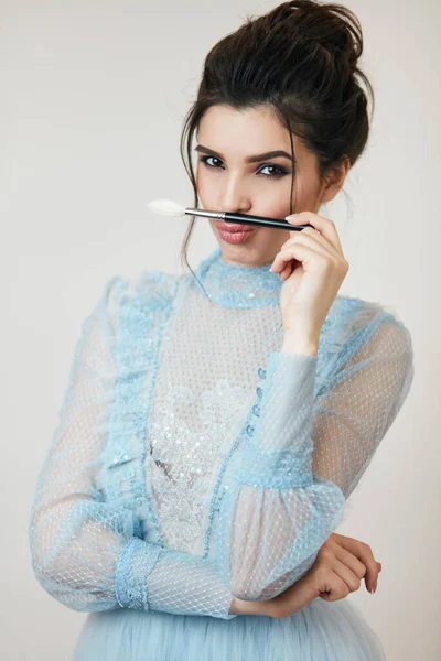 Komik kız bıyık gibi fırça kullanıyor.