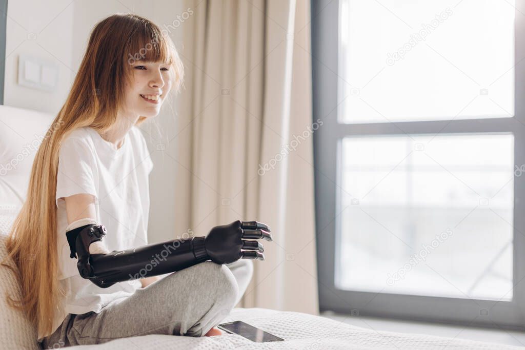 pale cheerful girl has put a cyber hand in the clinic