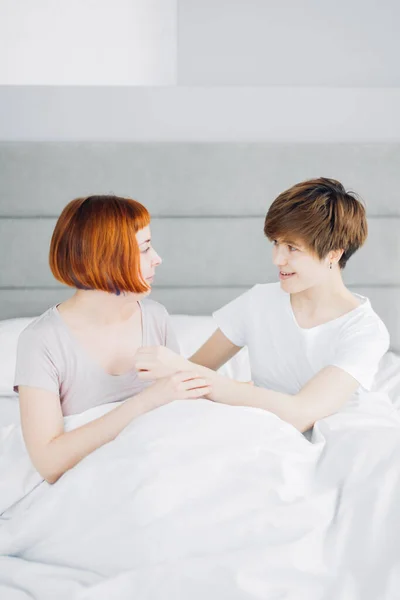 Дві найкращі друзі-жінки розмовляють під час відпочинку на ліжку в приміщенні — стокове фото