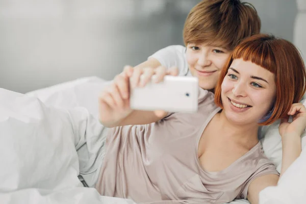 Twee mooie lesbiennes het nemen van een selfie terwijl liggend op het bed — Stockfoto