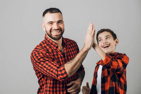 Knappe man geven high five naar zijn zoon op witte achtergrond — Stockfoto