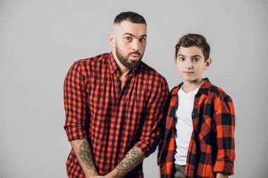 Adam ve korkmuş suratlı küçük adamı kameraya bakıyor.