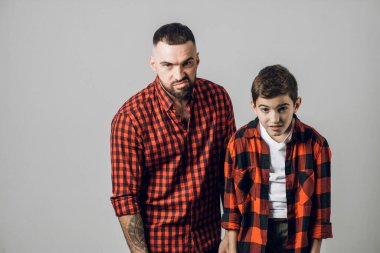 Mutsuz, sinirli, sinirli baba ve oğlu kameraya bakıyor..