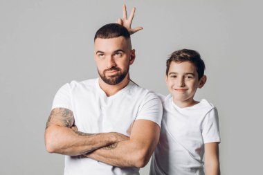 Komik çocuk, mutsuz babasının kafasında ellerini tutuyor.