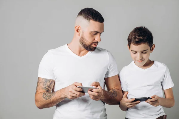 Bambino e suo padre e utilizzando il telefono. — Foto Stock