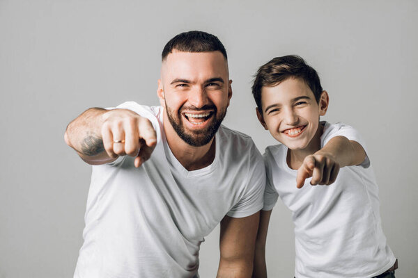 dad and son are indicating to the camera