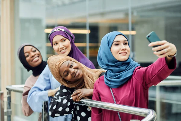 Musulmanes estudiantes multirraciales en hijabs tomando selfie en la sala de la universidad — Foto de Stock