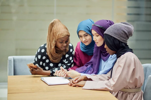 Mujeres islámicas asiáticas compartiendo información desde un smartphone durante su visita a un seminario — Foto de Stock