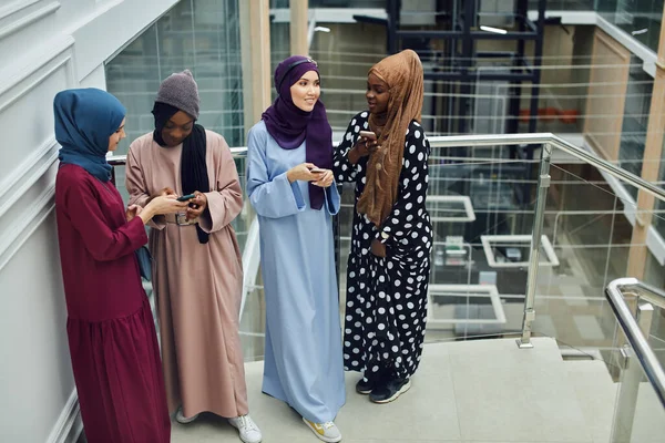 Grupo multiétnico musulmán de chicas mira el teléfono inteligente en la mano de la mujer africana — Foto de Stock