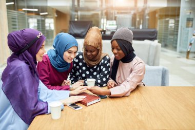 Ulusal giysiler içinde grup halinde poz veren çok ırklı Müslüman kadınlar.