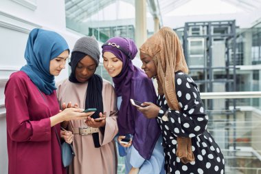 Asyalı Müslüman kadınlar bir seminer sırasında akıllı telefondan bilgi paylaşıyorlar