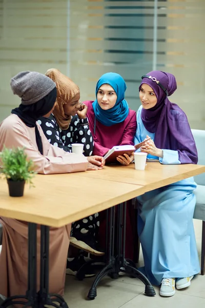 Muslimische junge Frauen unterschiedlicher ethnischer Zugehörigkeit sprechen über neues Buch berühmter Autorin — Stockfoto
