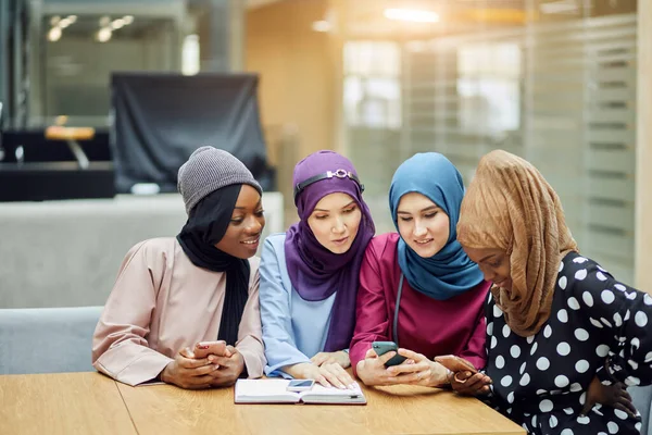 Mujeres islámicas asiáticas compartiendo información desde un smartphone durante su visita a un seminario — Foto de Stock