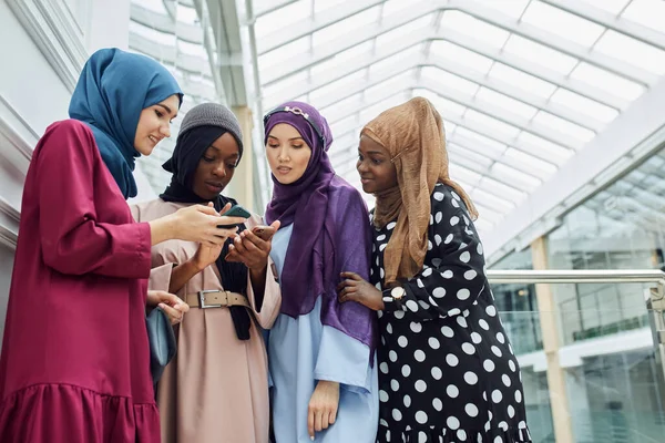 Mujeres islámicas asiáticas compartiendo información desde un smartphone durante su visita a un seminario — Foto de Stock