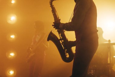 Elinde saksafon tutan bir müzisyen. Kenar görünümü kırpılmış fotoğrafı kapat.