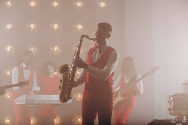 Saksafonlu havalı adam kameraya poz veriyor.